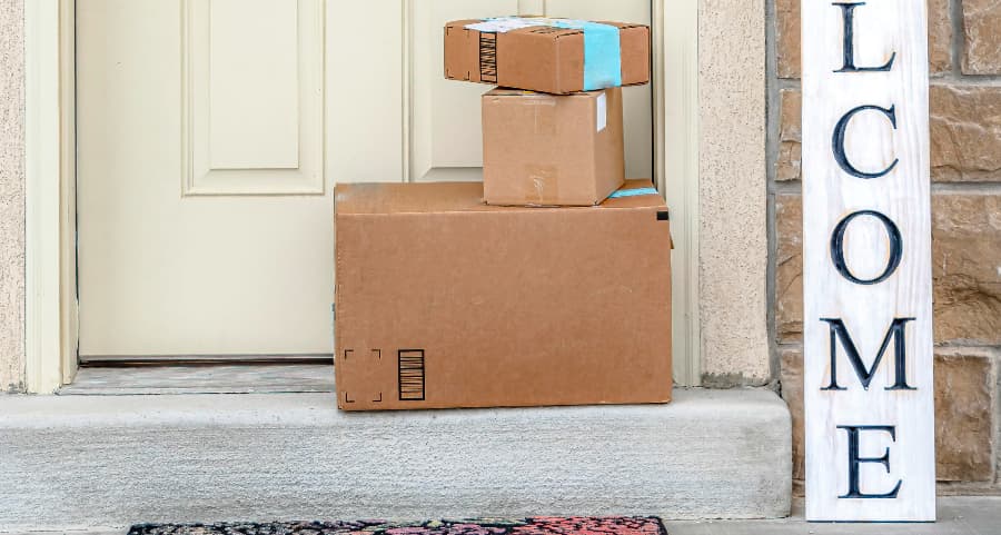 Boxes by the door of a residence with a welcome sign in Miami